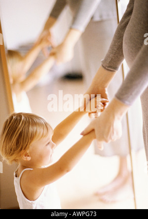 Child holding pregant woman's hands in front of mirror Stock Photo