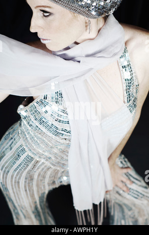 Young woman in silver evening gown and cap Stock Photo