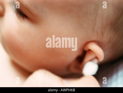 Baby having ear cleaned with cotton swab, close-up Stock Photo