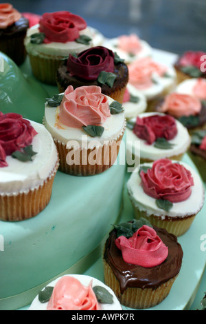 Tiers of cupcakes with red rose frosting on display. Photo by Tom Zuback Stock Photo