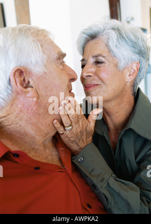 Senior couple, woman caressing man's face