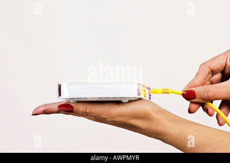 Plugging a LAN cable into router Stock Photo