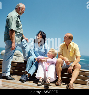 Two mature couples, sea in background Stock Photo