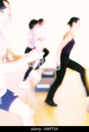 People doing step aerobics, side view, blurred Stock Photo