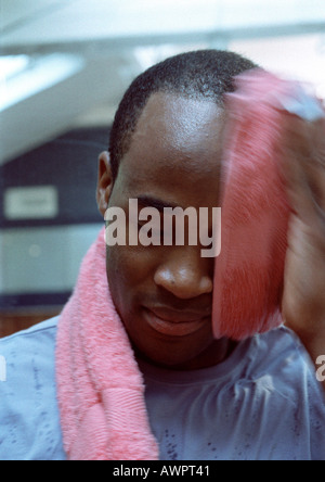 Man wiping off face with towel, close-up Stock Photo