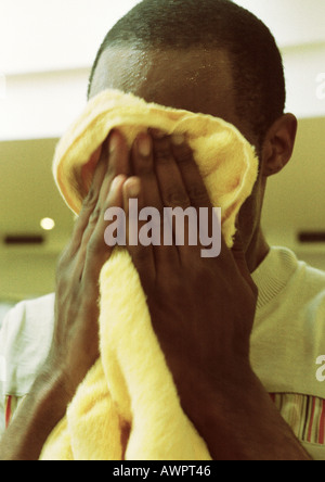 Man wiping off face with towel, close-up Stock Photo