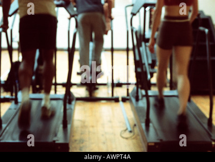People using exercise equipment in gym, lower section Stock Photo