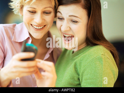 Two young women using cell phone, portrait Stock Photo