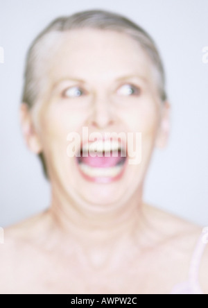 Mature woman with mouth wide open, close-up, portrait, blurred Stock Photo