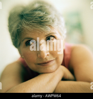 Portrait of mature woman arms crossed under chin, close-up Stock Photo