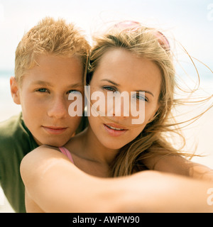 Portrait of young woman with boy resting chin on her shoulder Stock Photo