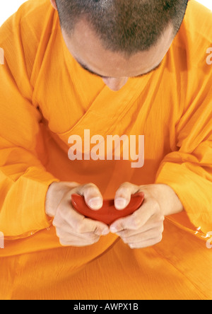 Buddhist monk meditating, holding scroll Stock Photo