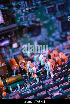 Toy figures on computer circuit board, close-up Stock Photo