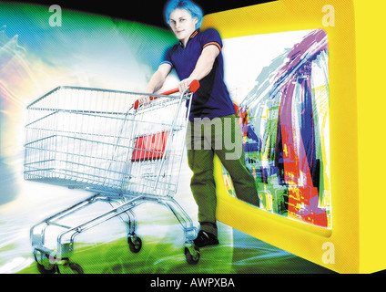 Young man emerging from computer monitor, pushing shopping cart, digital composite. Stock Photo