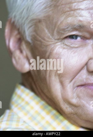 Senior man looking into camera, partial view, close-up. Stock Photo