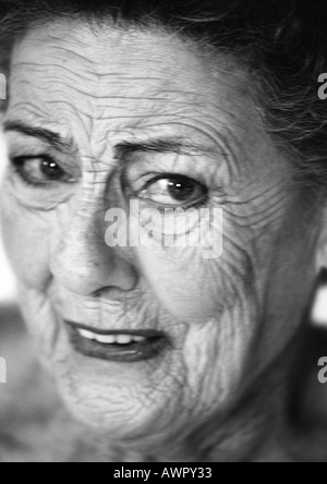 Senior woman looking into camera, close-up, portrait, b&w. Stock Photo