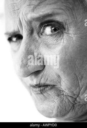 Elderly woman raising eyebrow, looking at camera, portrait, close-up, b&w Stock Photo