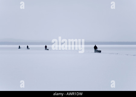 Four dog sled teams with mushers, frozen Lake Laberge, Yukon Territory, Canada Stock Photo