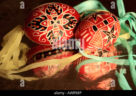 two traditional handpainted red and black geometric Czech Easter eggs with aqua and yellow ribbon Stock Photo