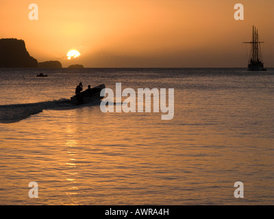 Carribean Sunset over Admiralty Bay, Port Elizabeth, Bequia with a local taxi boat and schooner SS Friendship Rose on the horizon Stock Photo