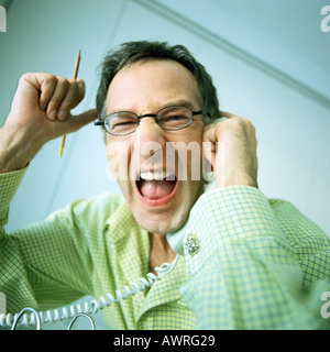 Man holding phone, shouting, portrait Stock Photo