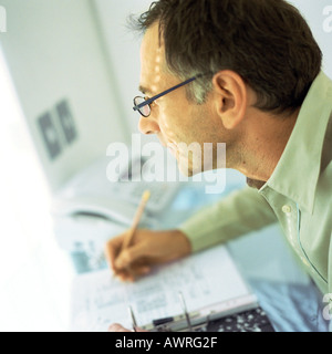 Mature man writing, side view Stock Photo