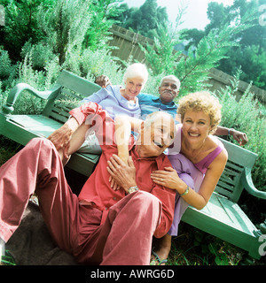 Two mature couples sitting outdoors, smiling Stock Photo