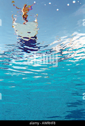 Person standing on diving board about to dive, underwater view. Stock Photo