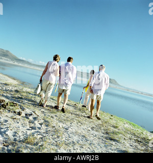 Two mature couples walking by the sea, rear view Stock Photo