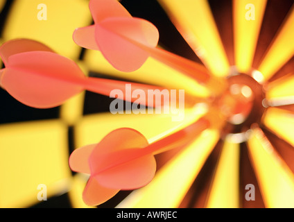 Darts in bull's-eye of dartboard, close-up Stock Photo
