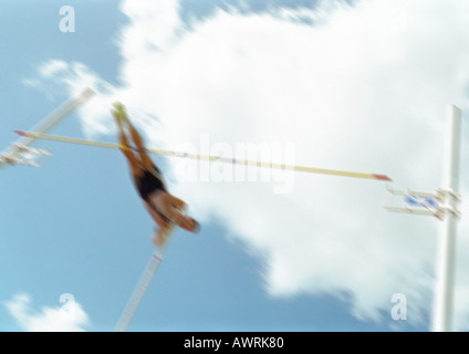 Male pole vaulter in mid-air, blurred motion Stock Photo