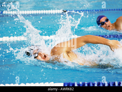 Male swimmers swimming freestyle in pool, close-up Stock Photo