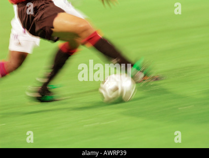 Soccer players running with ball, lower section, blurred. Stock Photo