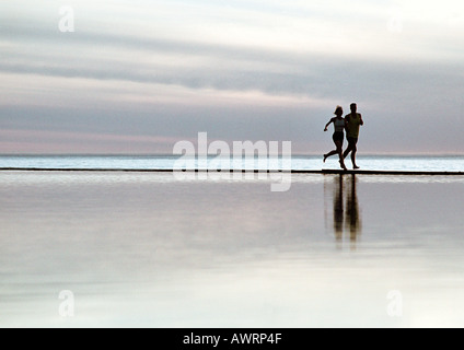 Couple running on beach Stock Photo
