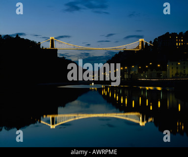 Night time view of Isambard Kingdom Brunel’s Clifton Suspension Bridge lit up and reflected in River Avon below Bristol England Stock Photo