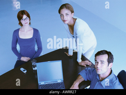 Business people around desk, smiling, elevated view Stock Photo