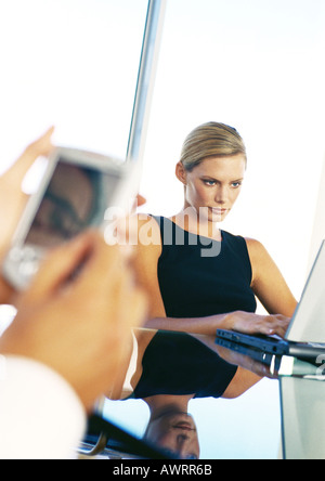 Businesswoman using computer, hands holding pocket computer Stock Photo