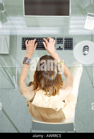 Woman at desk working on computer, elevated view Stock Photo