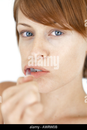 Woman brushing teeth, close-up, portrait Stock Photo