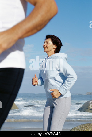 Mature couple running on beach Stock Photo