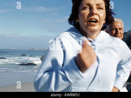 Mature couple running on beach, close-up Stock Photo