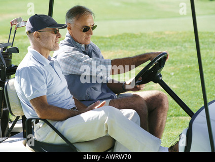 Two mature golfers in golf cart, close-up, side view Stock Photo
