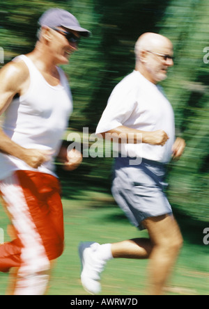 Two mature joggers in park, blurred motion Stock Photo