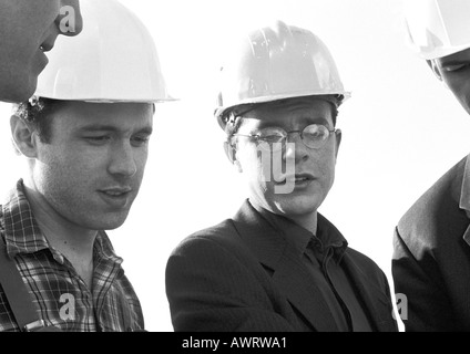 Men wearing hard hats, close-up, b&w Stock Photo
