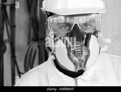 Man wearing hard hat, dust mask and glasses, close-up, b&w Stock Photo