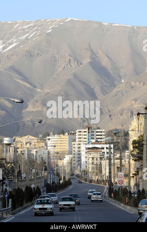 A view of North Tehran, with big mountains rising behind buildings and roads. Photo taken in Tehran, Iran. Stock Photo
