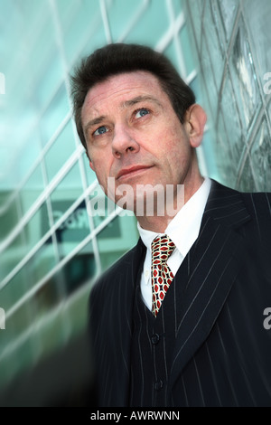 Business Man outside impressive glass building Stock Photo