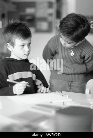 Two children, one holding pencil, b&w Stock Photo