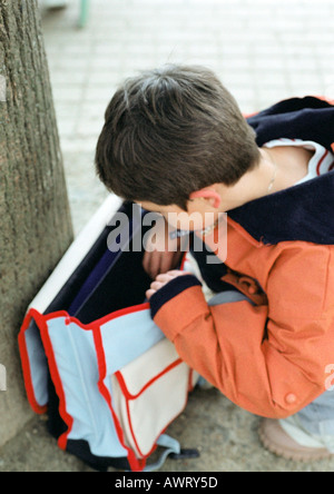 Child looking into backpack Stock Photo