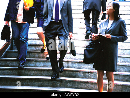 Businesswoman taking notes in front of stairs Stock Photo